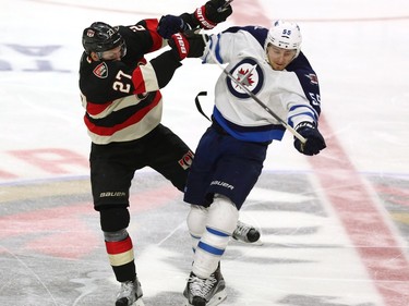 Winnipeg Jets' Mark Scheifele (55) collides with Ottawa Senators' Curtis Lazar (27) during second period NHL hockey action, in Ottawa, on Thursday, Nov. 5, 2015.