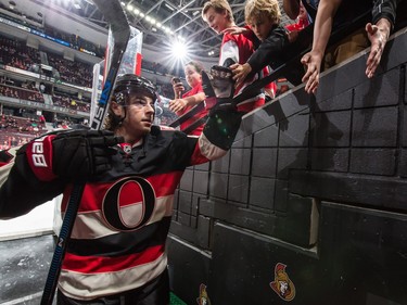 Jean-Gabriel Pageau #44 of the Ottawa Senators high-fives fans as he leaves the ice after the warmup.