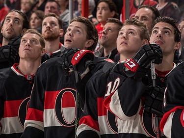 Left to right: Jared Cowen #2, Chris Neil #25, Andrew Hammond #30, Zack Smith #15, Curtis Lazar #27 and Shane Prince #10 of the Ottawa Senators look up at a video presentation in honor of Remembrance Day.