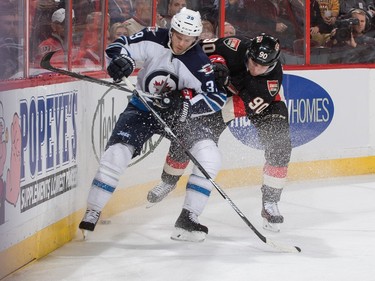 Alex Chiasson #90 of the Ottawa Senators battles for position against Tobias Enstrom #39 of the Winnipeg Jets behind the net.