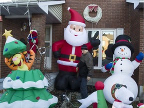 With 33 days to go until Christmas, Taffy Lane resident Elie Rizk checks to make sure the inflatable lawn figures are working properly.