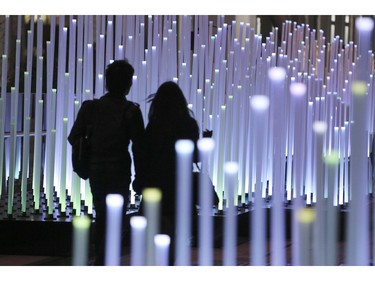 A couple walks through the special yearend illumination "Granroof Winter Installation" decorating the Granroof, the upper deck promenade of Yaesu gate at Tokyo Station, in Tokyo Friday, Dec. 25, 2015. The Granroof is illuminated every night until Jan. 11.