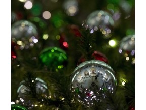 A man is reflected in a Christmas ball on a tree in the Foyer of the House of Commons Thursday, December 4, 2014 in Ottawa.