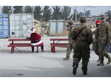A U.S. soldier dressed as Santa Claus waves to fellow troop  son Christmas day at the U.S. air base in Bagram, north of Kabul, Afghanistan, Friday, Dec. 25, 2015.