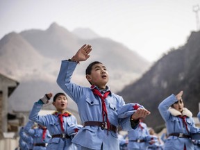In a picture taken on January 21, 2015, children dressed in uniform sing after raising the national flag at the Beichuan Red army elementary school in Beichuan, southwest China's Sichuan province.