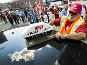 Around 100 protesters, many of them Airport Taxi drivers, march around Ottawa City Hall in September to protest their continued lockout by Coventry Connections and to call on the city to do more to crack down on Uber drivers.