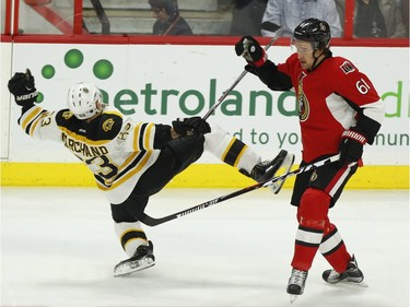 Ottawa Senators' Mark Stone (61) checks Boston Bruins' Brad Marchand (63) during first period NHL hockey action in Ottawa on Sunday, December 27, 2015.