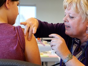 Renée Larocque delivers a vaccine during an Ottawa Public Health clinic in March 2015.