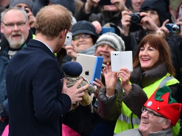 Britain's Prince Harry poses with a teddybear as he greets wellwishers after attending a traditional Christmas Day Church Service at Sandringham in eastern England, on December 25, 2015.