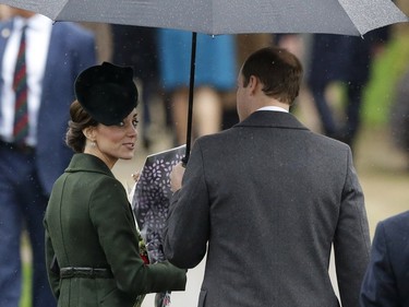 Britain's Prince William, right and his wife Kate the Duchess of Cambridge shelter under an umbrella, as they leave after attending the traditional Christmas Day church service at St. Mary Magdalene Church in Sandringham, England, Friday, Dec. 25, 2015.
