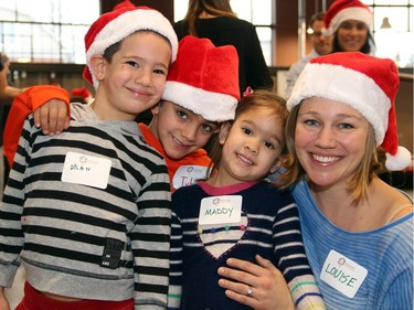 Busy mom Louise Malhotra, from the Malhotra Family Foundation, had sons Dylan and Tyler and daughter Maddy helping to fill the food hampers at an event organized by the Caring ahd Sharing Exchange for its Christmas Exchange Program, held at the Horticulture Building at Lansdowne on Friday, December 18, 2015. (Caroline Phillips / Ottawa Citizen)
