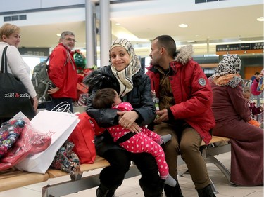 Canadians getting off a plane welcomed the young refugee family (Kaffa Alwane, her husband, Tamer Al Tadmory and their one-year-old daughter, Saloa) as they waited for their bags. A couple of dozen Syrian refugees, who seemed tired but happy,  arrived at Ottawa's airport Tuesday (Dec. 29, 2015) to a welcoming group of volunteers handing out gifts. The group was taken from the airport in a bus to downtown, but not before feeling the chill of the capital's first winter snowstorm.