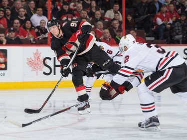 Alex Chiasson #90 of the Ottawa Senators shoots the puck against Michal Rozsival #32 of the Chicago Blackhawks.