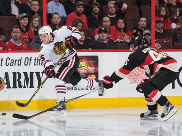 Andrew Shaw #65 of the Chicago Blackhawks shoots the puck against Chris Wideman #45 of the Ottawa Senators.