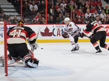 Tanner Kero #67 of the Chicago Blackhawks shoots the puck on a scoring chance against Craig Anderson #41 and Mark Borowiecki #74 of the Ottawa Senators.