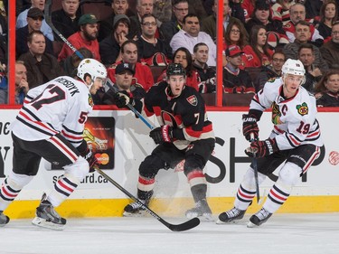 Kyle Turris #7 of the Ottawa Senators battles for puck possession against Trevor van Riemsdyk #57 and Jonathan Toews #19 of the Chicago Blackhawks.