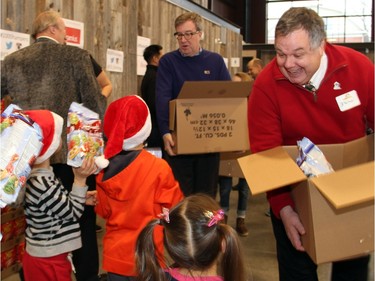 City councillor Jean Cloutier and Mayor Jim Watson were among the volunteers helping to pack 700 food hampers on Friday, December 18, 2015, at the Horticulture Building at Lansdowne for the Caring and Sharing Exchange and its annual Christmas Exchange Program. (Caroline Phillips / Ottawa Citizen)