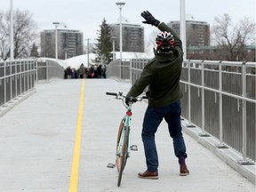 City councillor Mathieu Fleury waves to the mayor and others as they met halfway across the bridge.  Mayor Jim Watson, some city councillors and hundreds of happy local residents were on hand Dec 4, 2015 for the official opening of the new pedestrian bridge over the Rideau River.