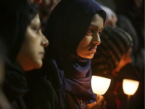 People participate in a candlelight vigil, held by the Council on American-Islamic Relations, for the victims in recent mass shootings December 4, 2015 at the Muslin Community Center in Silver Spring, Maryland. On Friday the FBI announced that it is investigating the San Bernardino shooting on Wednesday as an act of terrorism. One of the two suspects, Tashfeen Malik, reportedly pledged allegiance to the Islamic State on Facebook on the day of the shooting.