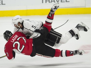 Los Angeles Kings defenceman Jamie McBain (5) and Ottawa Senators right wing Curtis Lazar collide during second period action.
