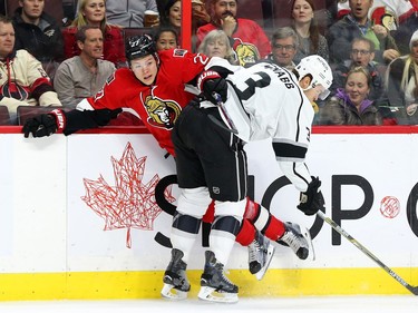 Curtis Lazar of the Ottawa Senators is hit by Brayden McNabb of the Los Angeles Kings during first period action.