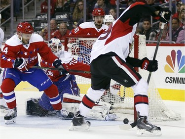 Ottawa Senators left wing David Dziurzynski, right, tries to shoot a rebound past Washington Capitals goalie Braden Holtby (70), with Capitals defenseman Taylor Chorney (4) helping Holtby, during the second period.