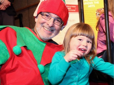 Dr. David Finestone, who volunteered in costume at the Christmas FanFair Concert presented by the National Arts Centre Orchestra Players' Association at the NAC on Sunday, December 13, 2015, is seen with three-year-old Autumn Marks, daughter of NACO principal violist Jethro Marks and NACO flutist Emily Marks.