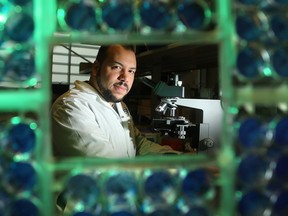 Dr. Jean-Simon Diallo, seen through plaque assays in his lab at the cancer research wing at the Ottawa Hospital.