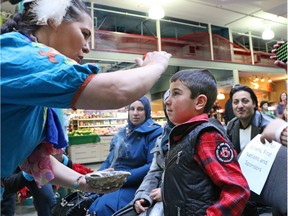 Members of the A-l Khodr family who arrived from Syria on November 30th take part in a native smudge ceremony with Samantha Evan at Eau Claire Market in Calgary on Thursday. The event was hosted by First Nations members to welcome Syrian refugees on International Human Rights Day.