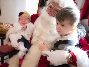 Two-and-a-half- year-old Matteo Tabicas and Naevia Tabicas, who is just over a month old visit with Santa at Elves of the Estate.