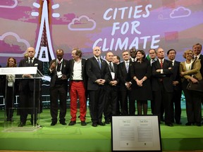 France's Foreign Minister Laurent Fabius (3-L), accompanied by Mayor of Paris Anne Hidalgo (5-R), former Mayor of New York City Michael Bloomberg (4-R) and others, before the Paris City Hall Declaration for COP21, after a meeting as part of the World Climate Change Conference 2015 (COP21) on December 4, 2015 in Paris. More than 150 world leaders are meeting under heightened security, for the 21st Session of the Conference of the Parties to the United Nations Framework Convention on Climate Change (COP21/CMP11) from November 30 to December 11.