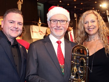 From left, Ottawa Food Bank executive director Michael Maidment with Douglas Burden, long-time bass trombonist of the National Arts Centre Orchestra, and Snowsuit Fund board member Sylvie Bigras at the orchestra's free Christmas FanFair Concert held in the NAC Main Foyer on Sunday, December 13, 2015, in support of the two local charities.