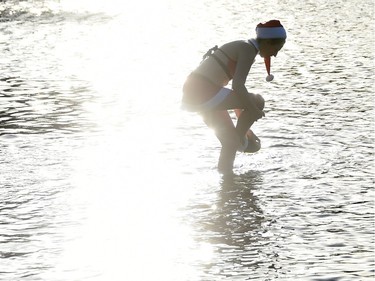 A member of the Berliner Seehunde (Berlin seals) swimming club wears a Father Christmas outfit during their traditional Christmas swimming on December 25, 2015 at the Orankesee lake in Berlin.