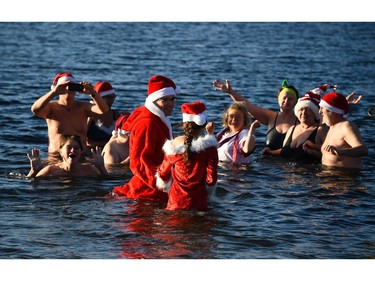 Members of the Berliner Seehunde (Berlin seals) swimming club wear Father Christmas outfits during their traditional Christmas swimming on December 25, 2015 at the Orankesee lake in Berlin.