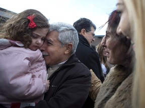 Hagop Manushian, centre left, meets his granddaughter Rita Mahserjian for the first time as his wife Elo Manushian and daughter Maria Karageozian, right, watch as Syrian refugees arrive at the Armenian Community Centre, in Toronto, on Friday, Dec. 11, 2015. The refugees arrived in the early hours of the morning on the first government-arranged flight to land at Toronto's Pearson Airport.