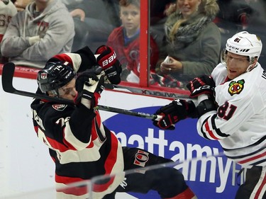 Ottawa Senators' Mark Borowiecki (74) and Chicago Blackhawks' Marian Hossa (81) battle in the corner during first period NHL action.