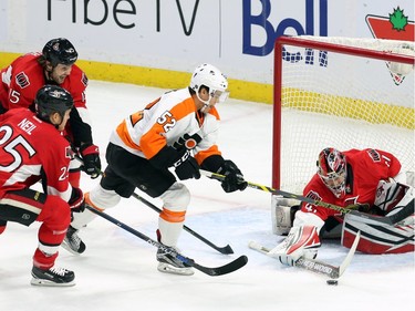 Ottawa Senators' goalie Craig Anderson (41) attempts to shovel the puck away as Philadelphia Flyers' Nick Cousins (52) closes in while the Senators' Zack Smith (15) and Chris Neil (25) react during first period NHL action.