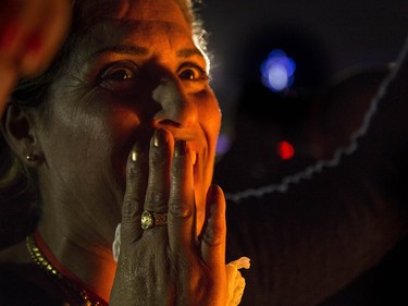 In this Thursday, Dec. 24, 2015 photo, an Iraqi Christian woman celebrates during Christmas Eve mass in the Al-Bashara Church in a Christian refugee camp in Irbil, northern Iraq. Many of the worshippers are displaced from their homes after Islamic State militants swept through northern Iraq in 2014.
