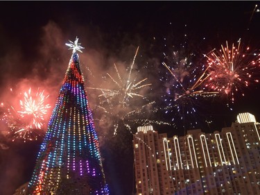 Fireworks explode next to a 38 metre Christmas tree on Christmas day at a shopping center in Jakarta on December 25, 2015.