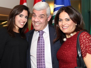 Jasmine Ibrahim, who works for Mayor Jim Watson's chief of staff, with her "Uncle Charlie" Saikaley, a real estate lawyer in Ottawa, and his wife, Majida Saikaley, at a holiday reception hosted by the mayor at his boardroom at City Hall on Wednesday, December 16, 2015. (Caroline Phillips / Ottawa Citizen)