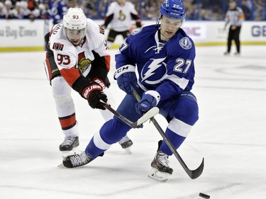 Tampa Bay Lightning left wing Jonathan Drouin (27) loses the puck to a stick-check by Ottawa Senators center Mika Zibanejad (93), of Sweden, during the first period.