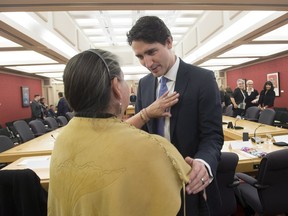 An aboriginal woman places her hand on Prime Minister Justin Trudeau's heart as he speaks with her at the start of a meeting with national aboriginal organizations on Parliament Hill  Wednesday December 16, 2015.