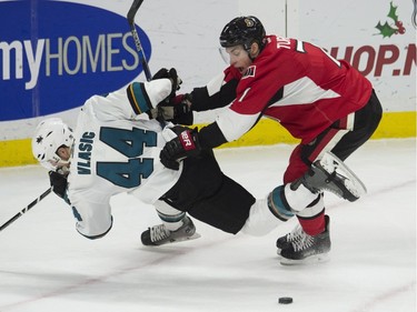 Ottawa Senators center Kyle Turris pushes San Jose Sharks defenseman Marc-Edouard Vlasic off the puck during first period NHL action.