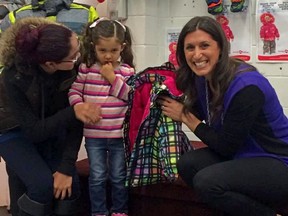 Lianne Laing, chair of The Snowsuit Fund, kicks off the 34th season with a young girl receiving her snowsuit.