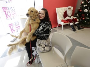 Lola sits on the lap of Brenna McKim before having her picture taken with Santa Paws.