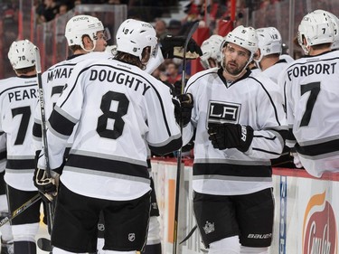 Jamie McBain #5 of the Los Angeles Kings celebrates his first period goal against the Ottawa Senators with teammate Drew Doughty #8.