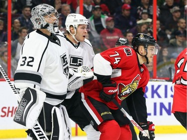 Mark Borowiecki of the Ottawa Senators playing forward against Jonathan Quick, left, and Brayden McNabb of the Los Angeles Kings during first period action.