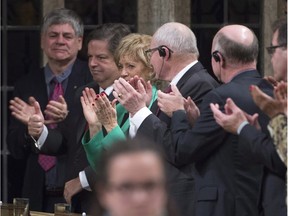 Liberal MP Mauril Belanger (second from left) gives a thumbs-up as he receives a standing ovation following Question Period in the House of Commons Wednesday December 9, 2015 in Ottawa.