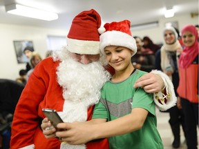Mohammad Al Meqdad takes a selfie with Santa during the Christmas party at the Maison Sophia reception house for refugees.