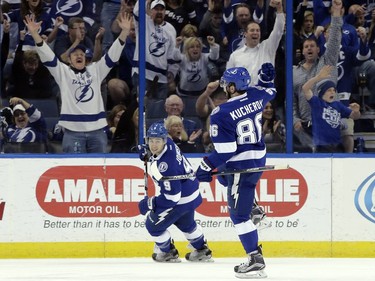 Fans, background, react as Tampa Bay Lightning right wing Nikita Kucherov (86), of Russia, celebrates his goal against the Ottawa Senators with teammate Tyler Johnson (9) during the first period.
